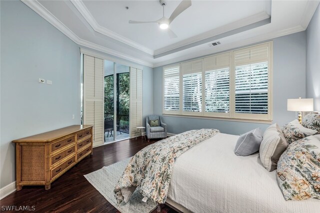 bedroom featuring access to exterior, a raised ceiling, ornamental molding, and dark wood-style flooring