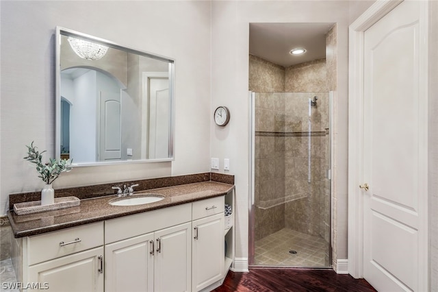 bathroom featuring a shower stall, vanity, and wood finished floors