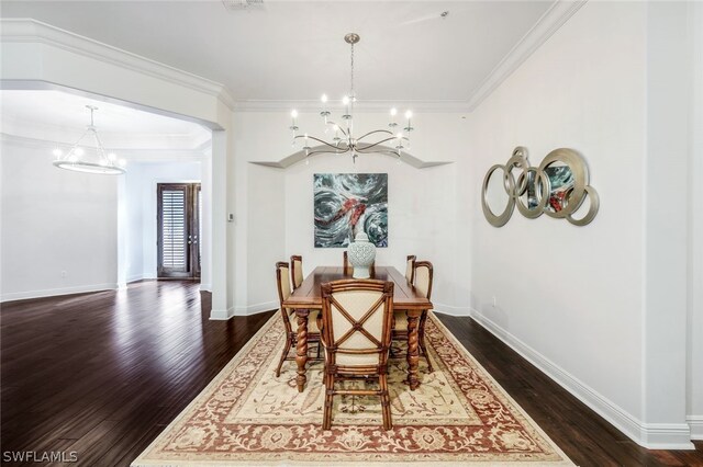 dining area with ornamental molding, an inviting chandelier, and dark hardwood / wood-style flooring