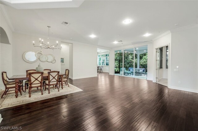 dining area with ornamental molding, an inviting chandelier, and dark wood-type flooring