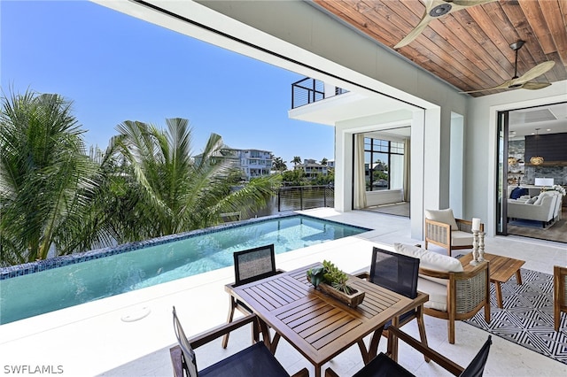 view of pool with a patio, an outdoor living space, and ceiling fan