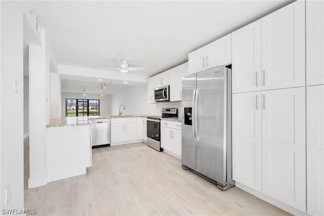 kitchen featuring white cabinetry, stainless steel appliances, kitchen peninsula, and sink