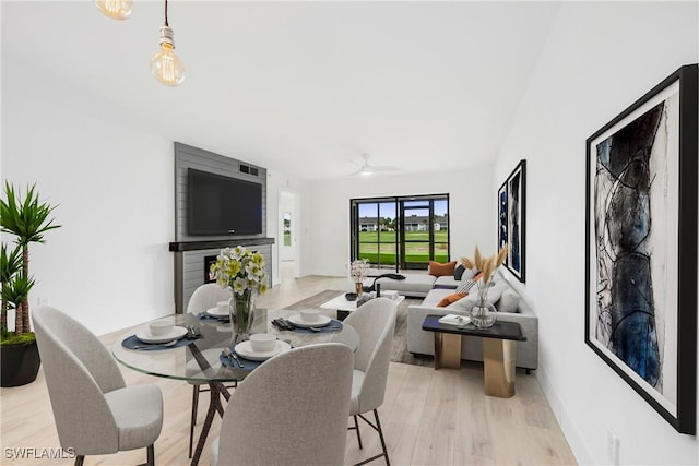 dining area with light wood-type flooring and ceiling fan