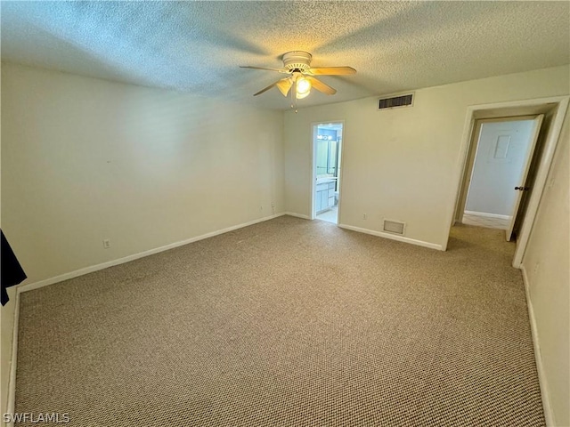 spare room featuring light colored carpet, ceiling fan, and a textured ceiling