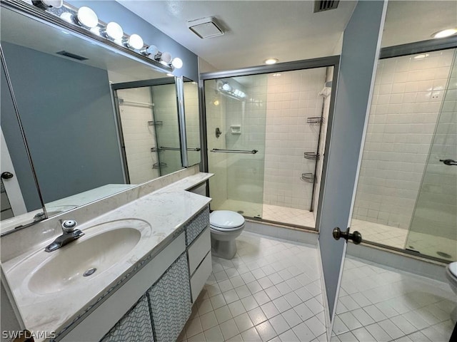 bathroom featuring vanity, an enclosed shower, tile patterned floors, and toilet