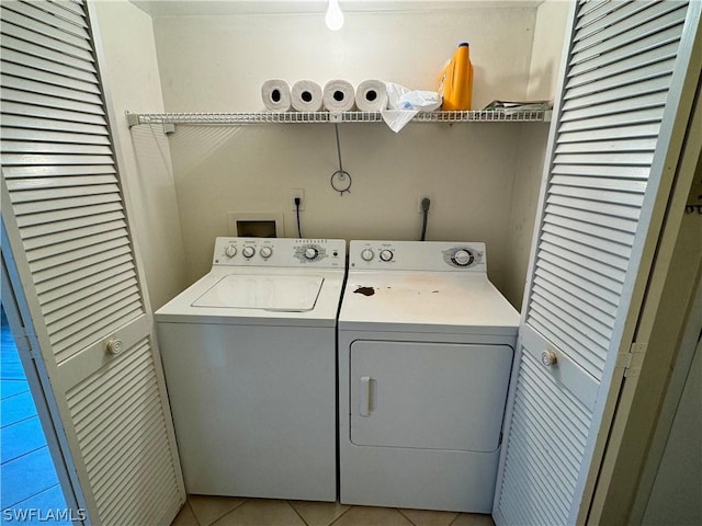 laundry room featuring light tile patterned flooring and separate washer and dryer