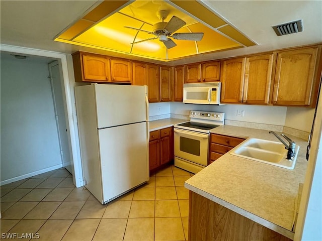 kitchen with white appliances, a raised ceiling, light tile patterned floors, and sink