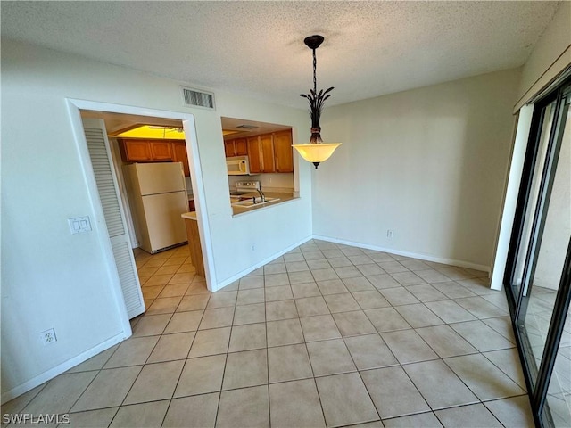 interior space with a textured ceiling and light tile patterned floors