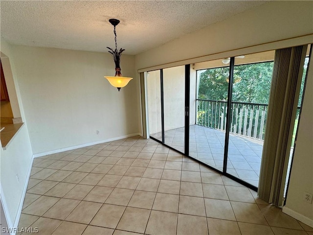 unfurnished dining area with a textured ceiling and light tile patterned floors