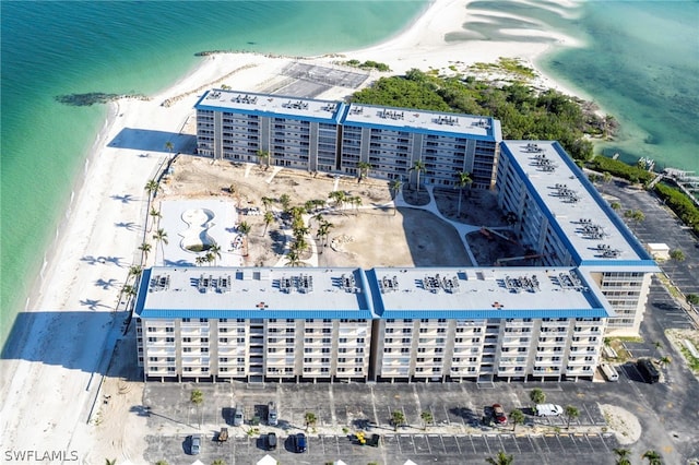 drone / aerial view with a water view and a beach view