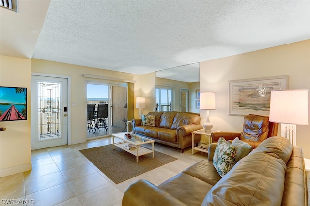 living room with a textured ceiling and light tile patterned floors