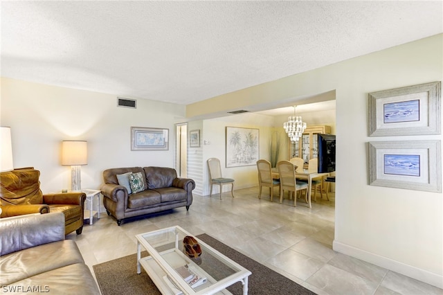 living room featuring a textured ceiling, a chandelier, and light tile patterned flooring