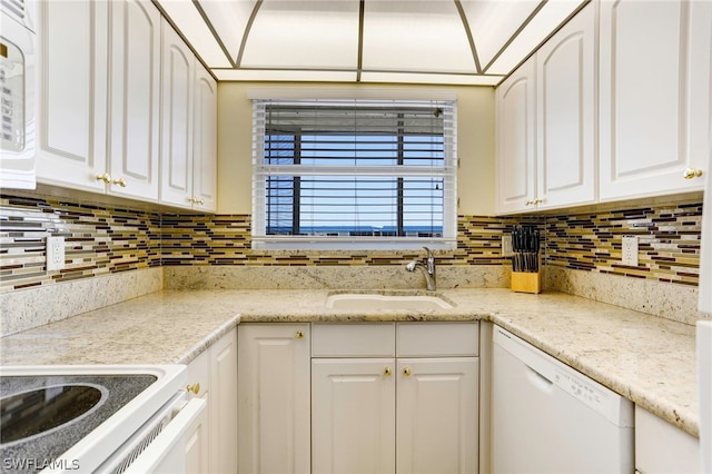 kitchen featuring tasteful backsplash, white cabinets, sink, and white appliances