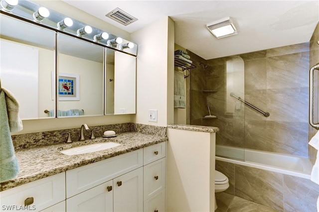 full bathroom with toilet, tile patterned flooring, tiled shower / bath, and vanity