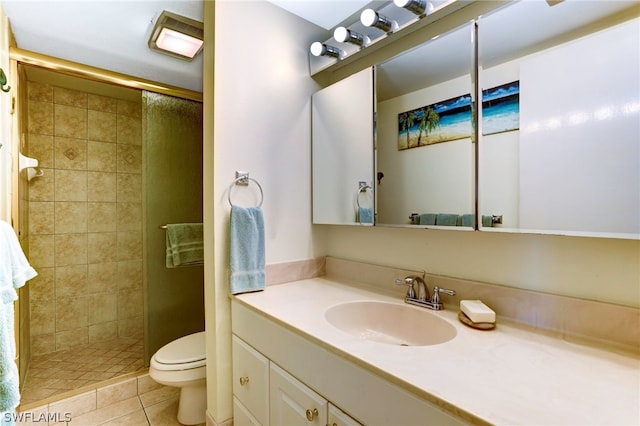 bathroom with toilet, tile patterned floors, a shower with door, and vanity