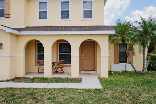 entrance to property with a lawn