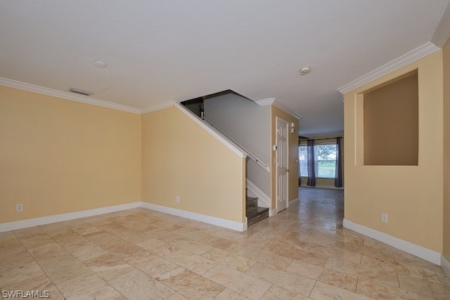 empty room featuring crown molding