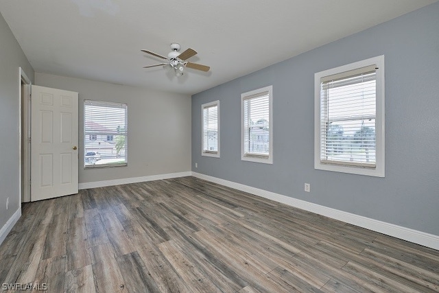 spare room with dark wood-type flooring and ceiling fan