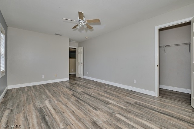 unfurnished bedroom with wood-type flooring, a closet, and ceiling fan