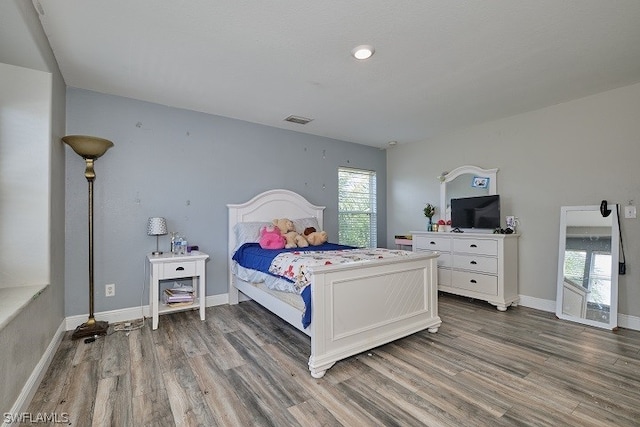 bedroom featuring multiple windows and dark wood-type flooring