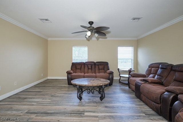 living room featuring wood-type flooring, plenty of natural light, ceiling fan, and crown molding