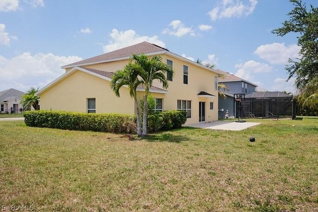 rear view of house with a patio area, glass enclosure, and a lawn