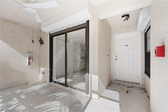 doorway to property featuring ceiling fan