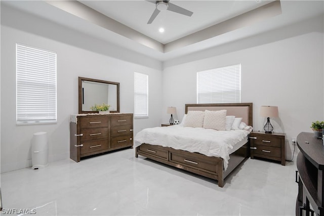 bedroom with a raised ceiling and ceiling fan