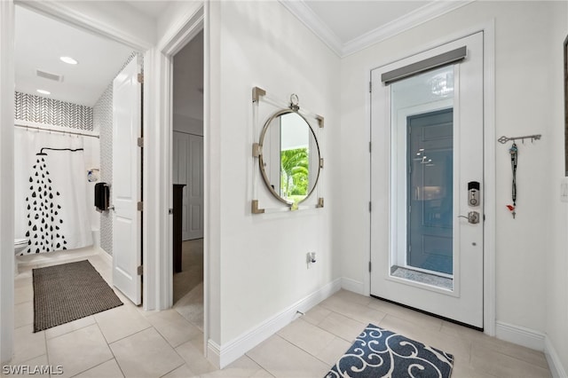 foyer with crown molding and light tile patterned floors