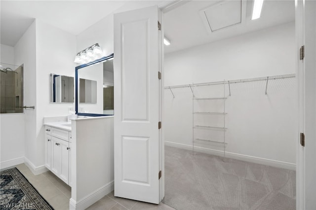 bathroom featuring tile patterned flooring, vanity, and walk in shower