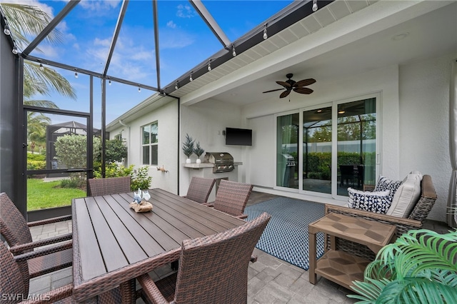 sunroom featuring beam ceiling and ceiling fan