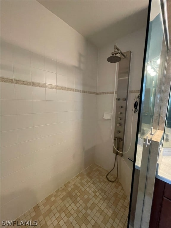 bathroom featuring vanity and tiled shower