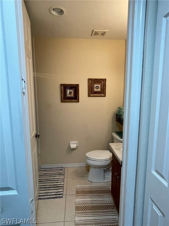 bathroom featuring tile patterned flooring, vanity, and toilet