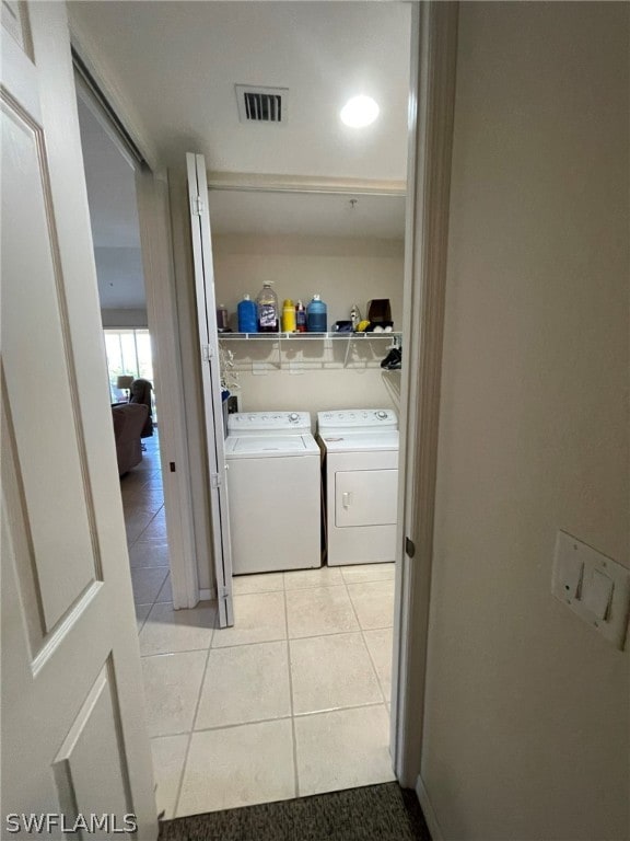 laundry room featuring washer and clothes dryer and light tile patterned floors