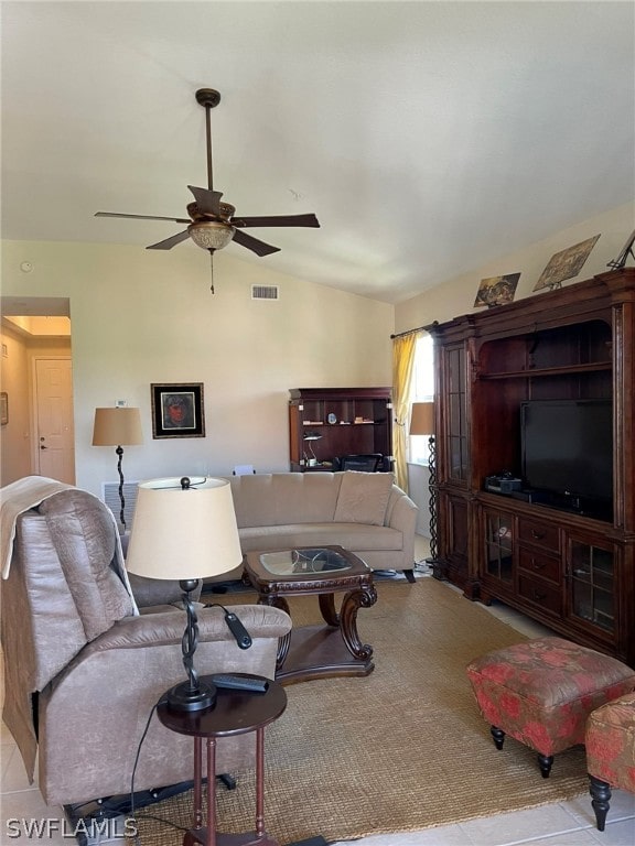 living room featuring ceiling fan, light tile patterned floors, and vaulted ceiling