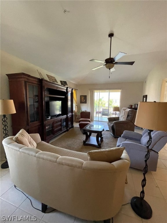 living room with lofted ceiling, ceiling fan, and light tile patterned floors