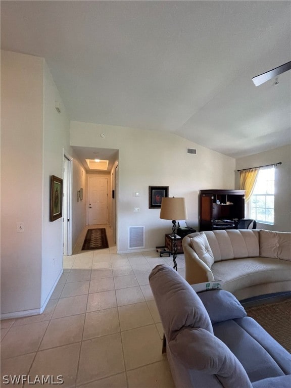 living room featuring ceiling fan, light tile patterned flooring, and lofted ceiling