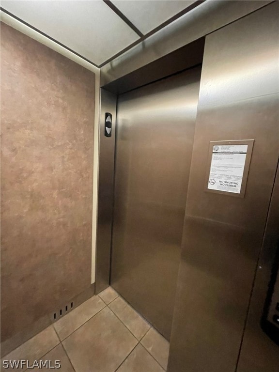 bathroom featuring elevator and tile patterned flooring