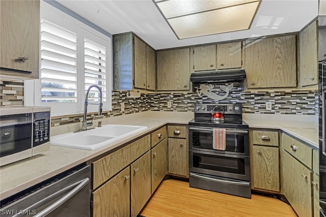 kitchen with light hardwood / wood-style flooring, appliances with stainless steel finishes, sink, and decorative backsplash