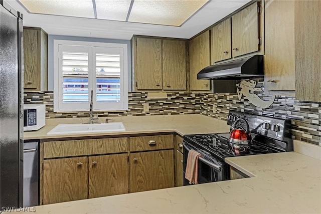 kitchen featuring decorative backsplash, stainless steel appliances, and sink