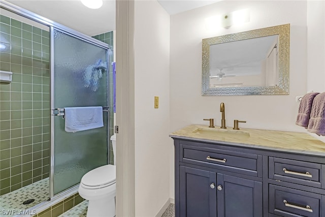 bathroom with tile patterned floors, a shower with door, vanity, and toilet