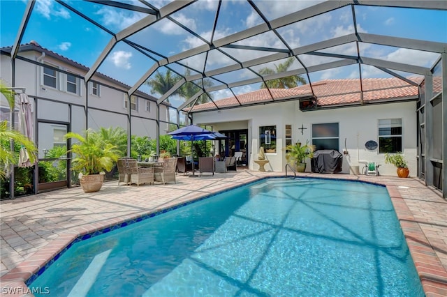 view of swimming pool featuring a patio, grilling area, and a lanai