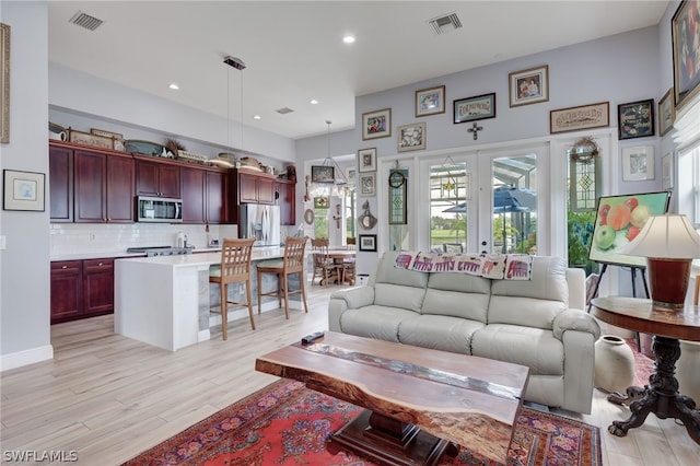 living room featuring french doors and light wood-type flooring