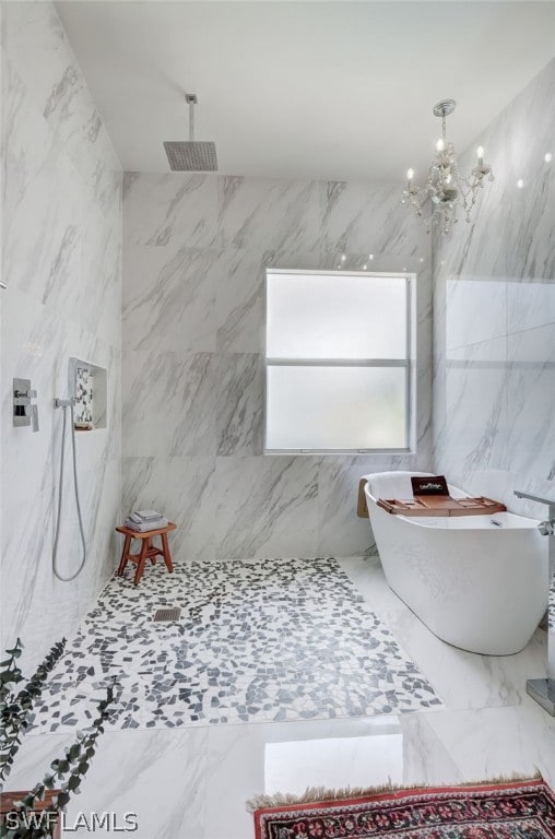 bathroom with tile walls, independent shower and bath, and an inviting chandelier