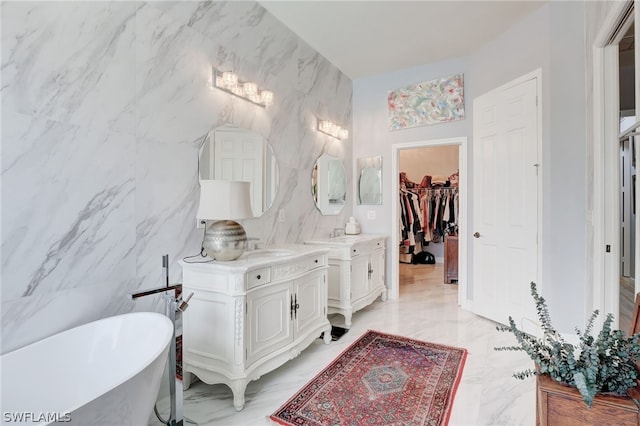 bathroom with a washtub, vanity, and tile walls