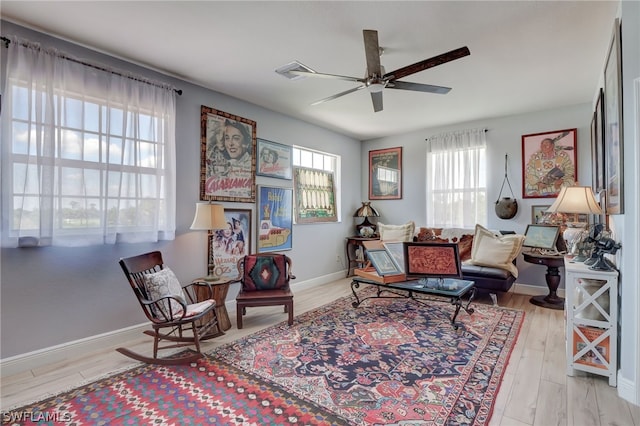 living area with plenty of natural light, light hardwood / wood-style floors, and ceiling fan