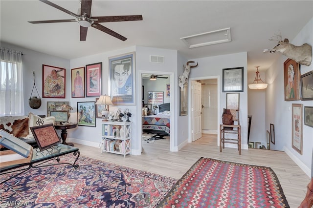 living area featuring light hardwood / wood-style flooring and ceiling fan