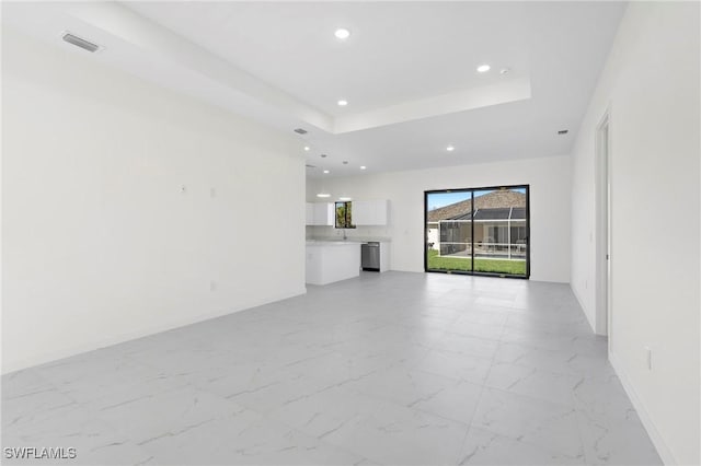 unfurnished living room with a tray ceiling