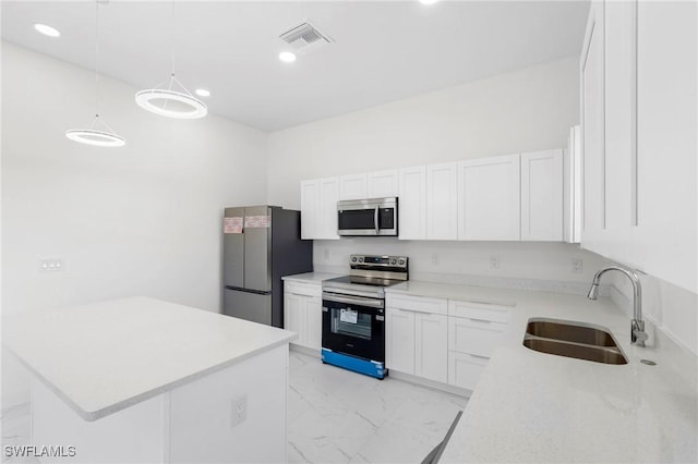 kitchen featuring sink, white cabinets, pendant lighting, and appliances with stainless steel finishes