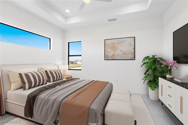 bedroom featuring ceiling fan and a tray ceiling